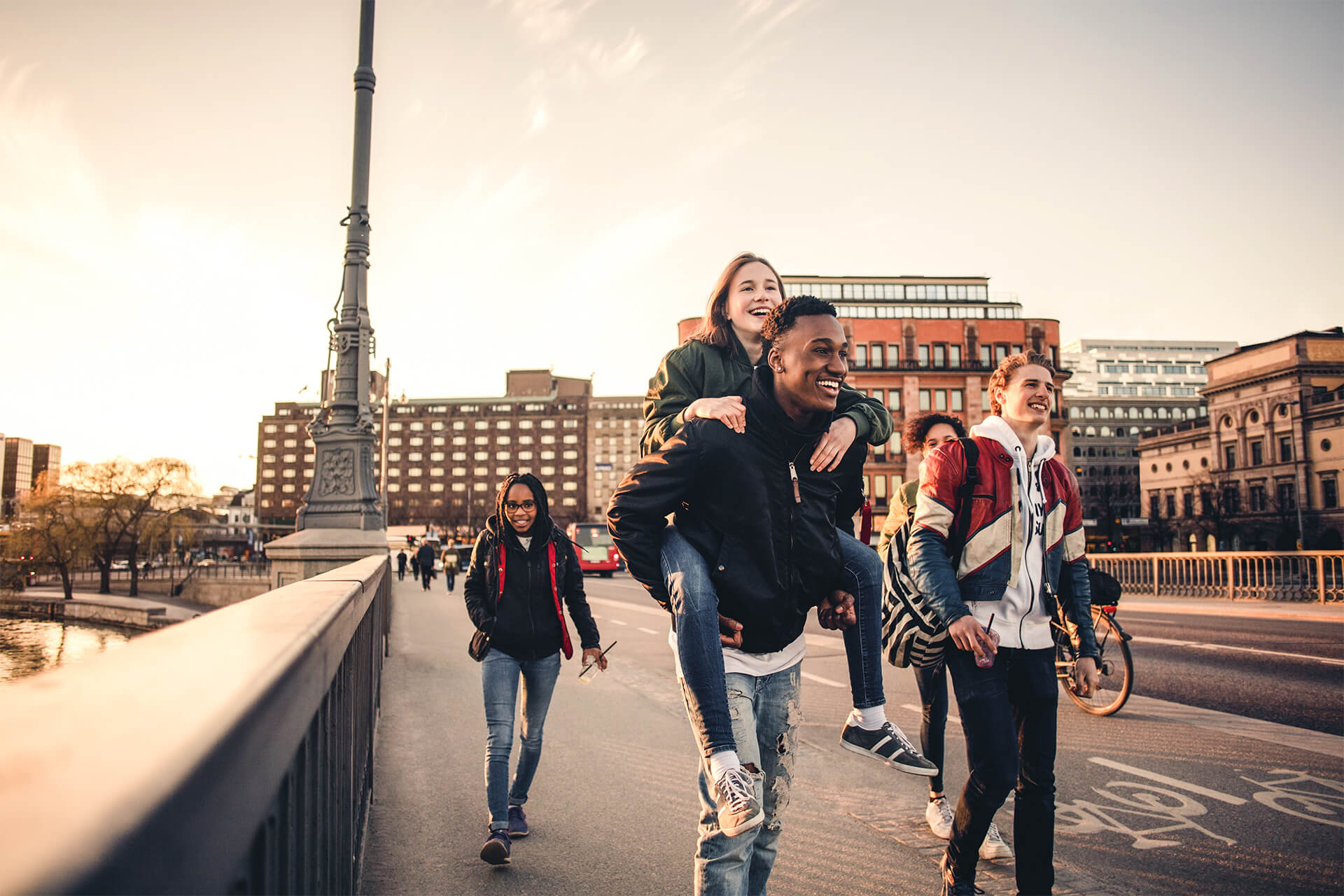 Mehrere Jugendliche laufen glücklich über Brücke