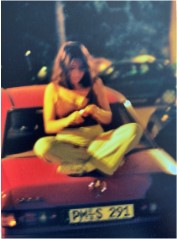 Foto einer Freundin, die am Abend auf dem Heck eines Autos sitzt.