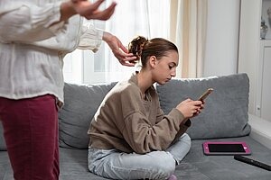 Mädchen mit Smartphone und Tablet auf dem Sofa