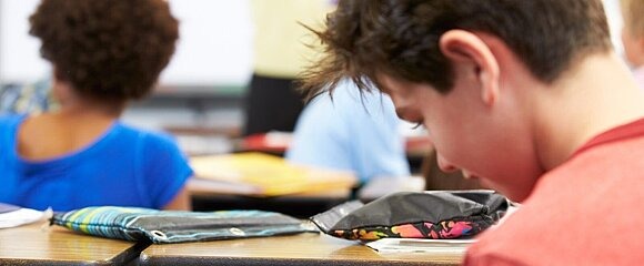 Schüler mit Smartphone in der Hand während des Unterrichts