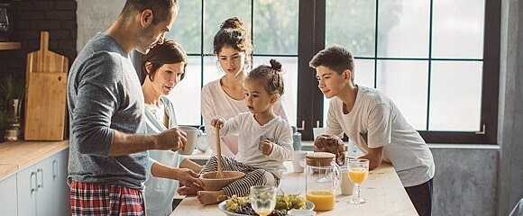 Eine Familie beschäftigt sich um einen Tisch