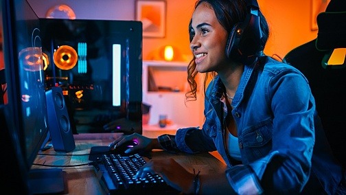 Junge Frau spielt lächelnd Computerspiele