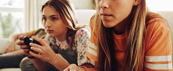 Zwei Mädchen spielen Videospiele zu Hause