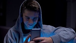 Junge schaut gebannt aufs Smartphone