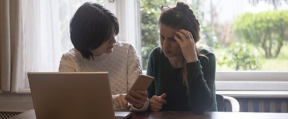 Mutter und Tochter sitzen vor dem Laptop