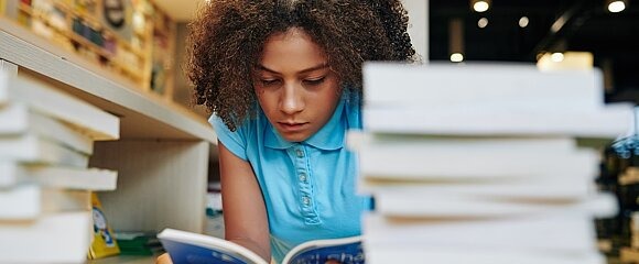 Jugendliche liest in Bibliothek