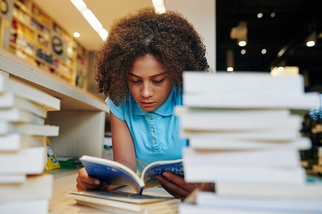 Jugendliche liest in Bibliothek
