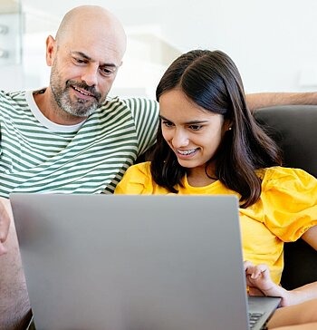 Vater und Tochter gemeinsam am Laptop