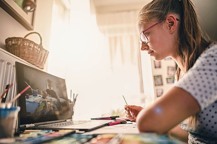 Mädchen lernt mithilfe eines Videos das Malen.