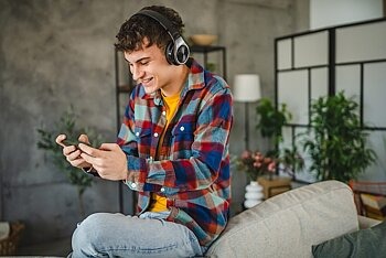Jugendlicher spielt Handygame mit Kopfhörern