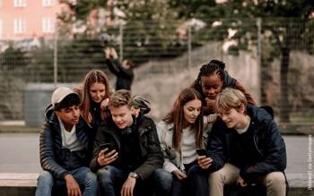 Jugendliche sitzen und gucken auf ihre Samrtphones
