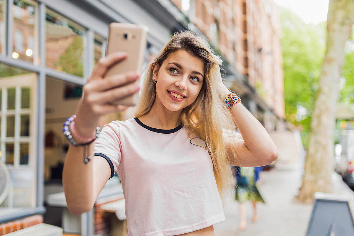 Jugendliche macht Selfi auf Straße