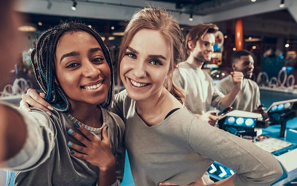 Zwei Mädchen machen Selfie auf Spielemesse