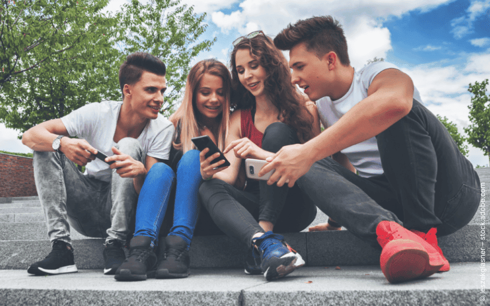 Gruppe Jugendliche draußen nutzt Smartphones