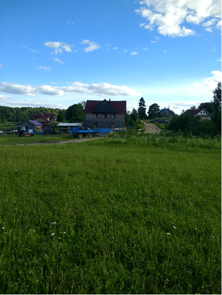 Idyllische Landschaft mit einer großen Wiese und einem kleinen Dorf am Horizont